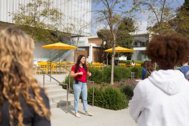 Tour Guide in front of LMU's School of File and Television talking with tour guests.